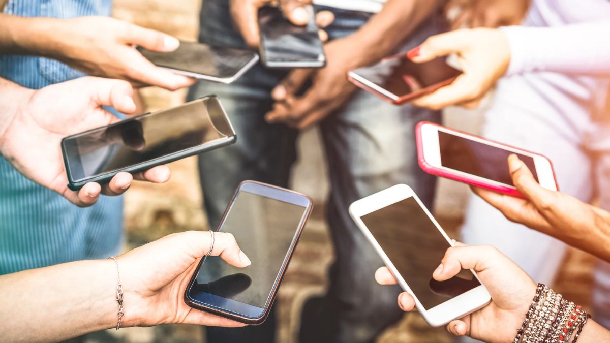Group of people using smartphones around a table