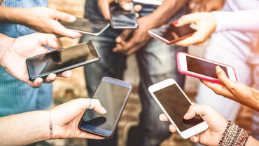 Group of people using smartphones around a table