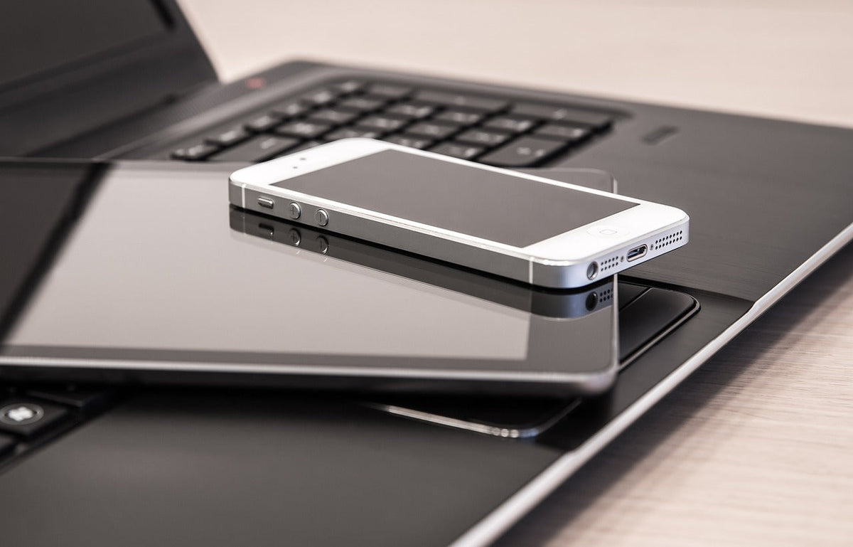 Smartphone stacked on electronic devices at a desk