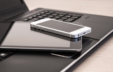 Smartphone stacked on electronic devices at a desk