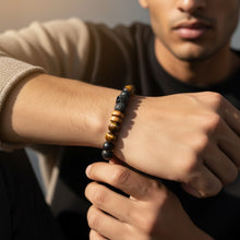 Close-up of EMF men’s bracelet with mixed black beads and tiger eye stones on wrist