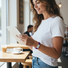 Woman wearing purple EMF protection bracelet BodyBand Plus using iPad