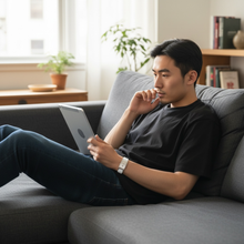 Man wearing white EMF protection bracelet BodyBand Plus watching tablet