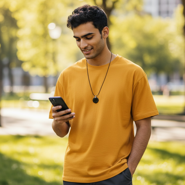 Man wearing EMF protection necklace classic octagon black pendant using phone