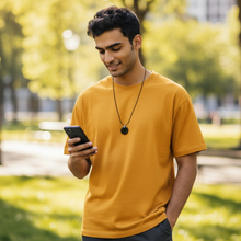 Man wearing EMF protection necklace classic octagon black pendant using phone