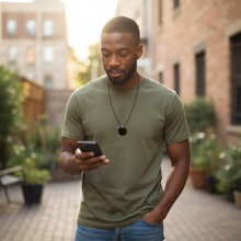 Man wearing EMF protection necklace classic octagon black pendant on smartphone