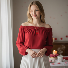 Woman wearing EMF protection necklace red Valentine heart pendant in restaurant