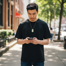 Man wearing stainless steel EMF protection dog tag necklace using iPhone