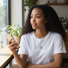 Woman wearing stainless steel EMF protection necklace octagon pendant using phone