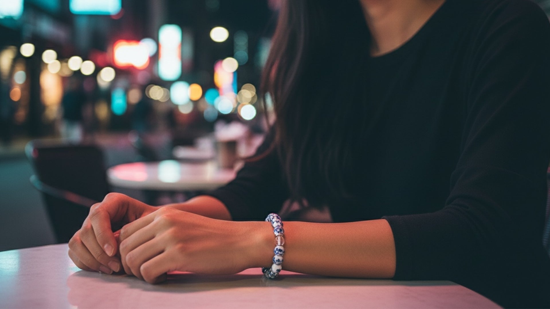 Woman wearing an EMF protection beaded bracelet with blue flower design, styled for everyday wellness and modern living.