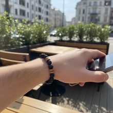 EMF Protection Beaded Bracelet for Men worn on wrist while using smartphone outdoors