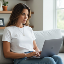 Woman wearing stainless steel EMF protection dog tag necklace using a MacBook laptop