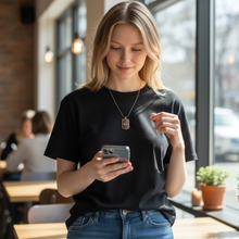 Woman wearing stainless steel EMF protection dog tag necklace using a phone