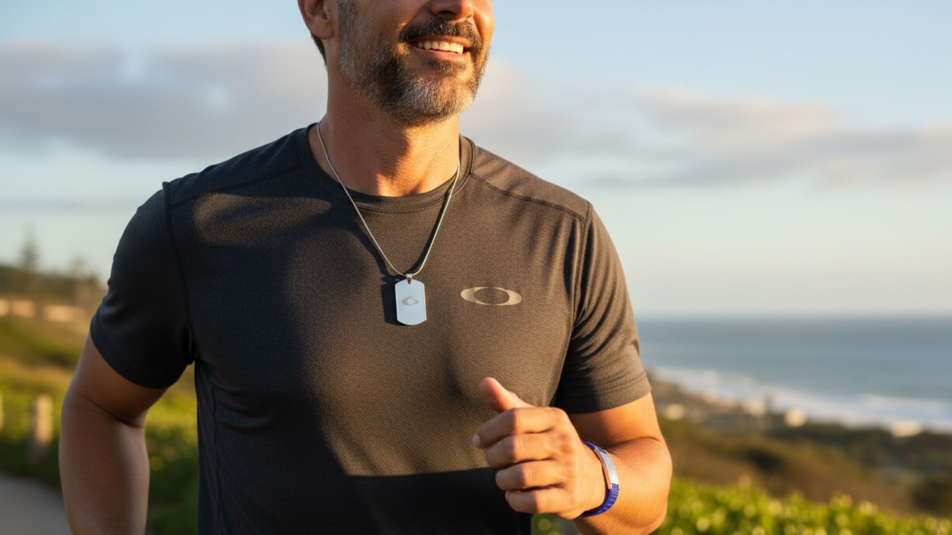 Male model wearing EMF protection wearables including stainless steel body shield and BodyBand Plus bracelet