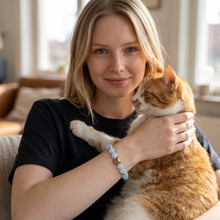 Woman holding her cat while wearing a Blue Cat Lover EMF Protection Bracelet designed for cat moms and pet lovers.