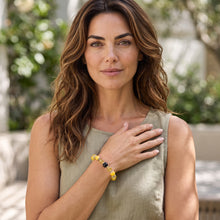 Woman wearing the Citrine EMF Protection Beaded Bracelet outdoors in a green top