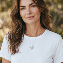 Model wearing a Clear EMF Protection Button Necklace featuring a stainless steel chain and wearable EMF protection technology.