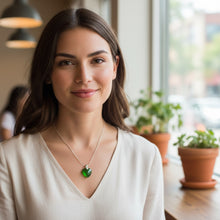 Close-up of emerald heart EMF harmonizer pendant with stainless steel bezel