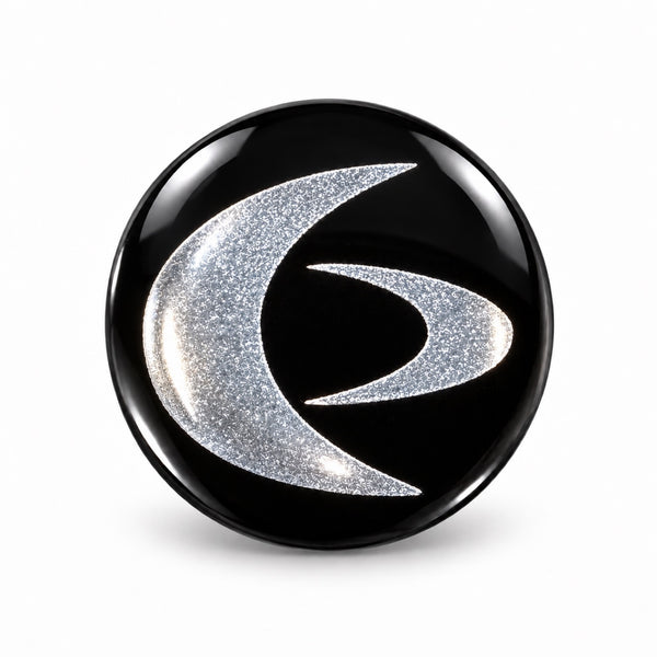 Silver on Black EMF Mini Shield – round phone sticker with a silver swirl design on a black background that harmonizes EMF from your phone