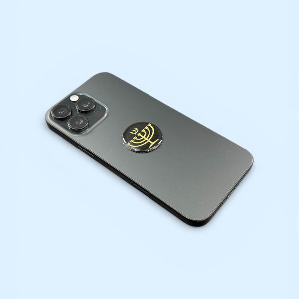 Gold Menorah EMF Protection Mega Shield applied to smartphone for device protection