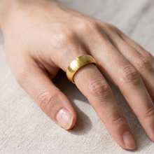 Gold EMF Protection Ring by Safe Connect Plus worn on the middle finger, showcasing a minimalist everyday wearable design.