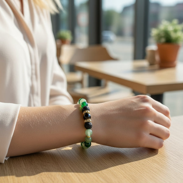 Woman wearing Evergreen EMF Protection Beaded Bracelet with green beads and gold accents in a natural lifestyle setting