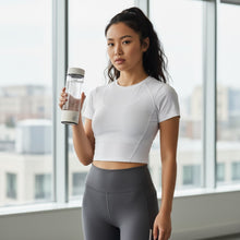 Woman holding hydrogen-rich water bottle with EMF protection for wellness and daily hydration