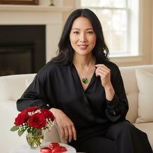 Large emerald heart EMF protection necklace worn with black outfit, silver chain visible on model