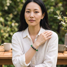 Woman wearing the Malachite EMF Protection Beaded Bracelet outdoors in a white shirt