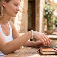Woman wearing the Moonstone EMF Protection Beaded Bracelet at a café table