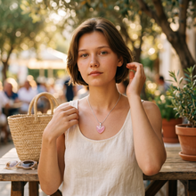 Woman wearing a Neon Pink Heart EMF Protection Necklace during a summer outing with a lightweight heart-shaped pendant.