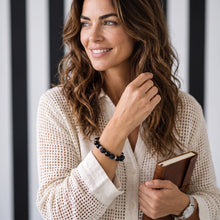 Woman wearing the Obsidian EMF Protection Beaded Bracelet while holding a book