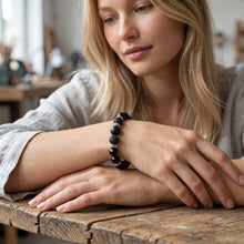 Woman wearing the Obsidian EMF Protection Beaded Bracelet at a wooden table