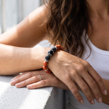 Woman wearing the Red Jasper EMF Protection Beaded Bracelet in sunlight
