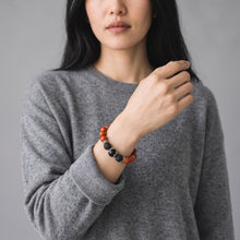 Woman in a grey sweater wearing the Red Jasper EMF Protection Beaded Bracelet