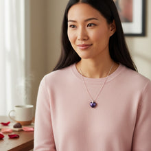 Woman wearing a small purple heart EMF protection necklace with a polished heart pendant designed for everyday wear