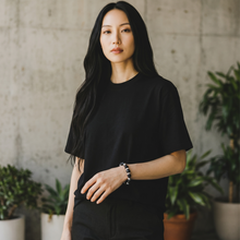 Model wearing the Ultimate EMF Protection Bracelet with matte black and metallic beads featuring triple resonant technology for stylish everyday EMF protection.